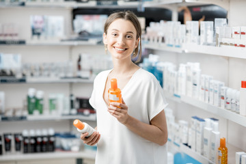 Woman choosing sunscreen lotion at the pharmacy