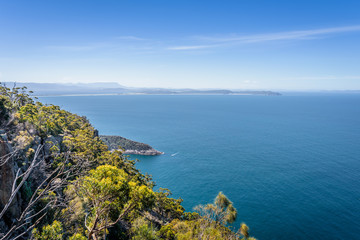 Fototapeta na wymiar Amazing view to great paradise island cliff bays with turquoise blue water and green shore jungle forest on warm sunny clear day relaxing hiking track to Fluted Cape, Bruny Island, Tasmania, Australia