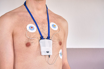 Fototapeta premium Man wearing 24 hrs electrocardiogram monitor device on his chest / heart investigation