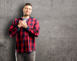 Young handsome man with hands in heart, expressing love and health concept