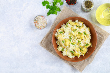 White steamed rice with slices of fried chicken fillet in a bowl on a concrete table. Top view.