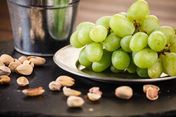 Pistachios and plums on wooden table