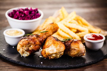Roast chicken drumsticks with chips and vegetables
