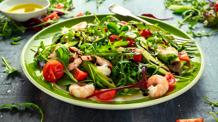 Fresh Avocado, shrimps salad with lettuce green mix, cherry tomatoes, herbs and olive oil, lemon dressing. healthy food