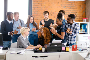 lauging young people are congratulating their ginger friend warmly on her exam results in the room...
