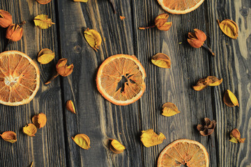 orange slices and petals of dried flowers on wooden background