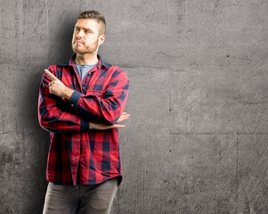 Young handsome man pointing away side with his finger