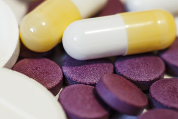 A handful of white, purple and yellow tablets