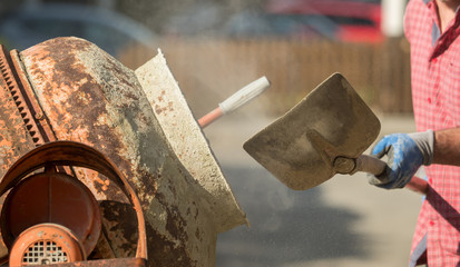 Construction site work with concrete mixer and wheelbarrows