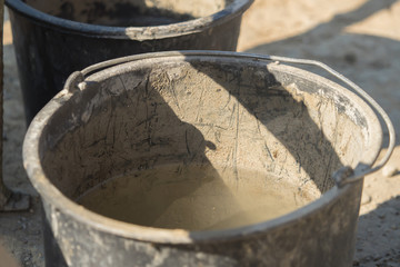 Construction site work with concrete mixer and wheelbarrows