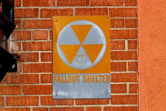 Orange "Fallout Shelter" sign on a brick wall. With North Korea performing nuclear missile tests, Fallout Shelters may become more popular I