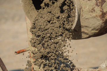Construction site work with concrete mixer and wheelbarrows