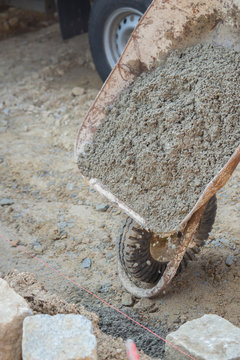 Construction site work with concrete mixer and wheelbarrows