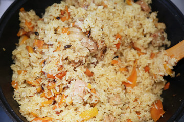 Preparation of rice dishes - pilaf from Uzbekistan. All the contents of the pan are thoroughly mixed, the pilaf is ready.
