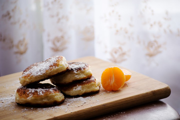Cheese croutons with tangerine lying on a wooden board