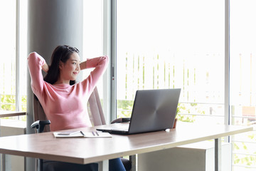 Businesswoman sitting in the office happily.