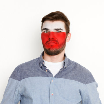 Young man with Poland flag painted on his face