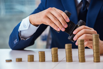 Businessman with stacks of coins in the office