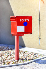 Red metal mailbox of national and international state Polish postal service stands at wall on...