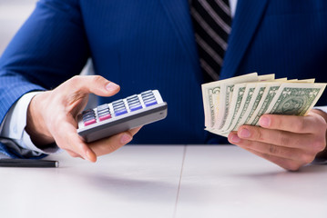 Accountant calculating dollars with calculator in office