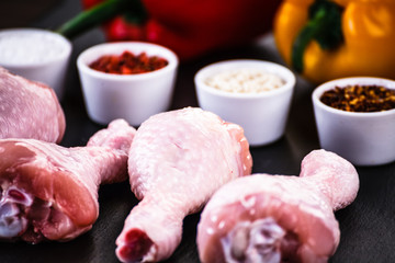 Raw chicken drumsticks on wooden background