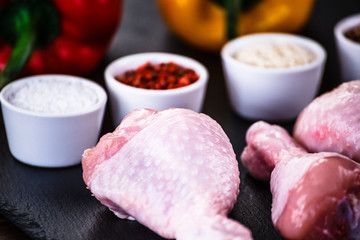 Raw chicken drumsticks on wooden background