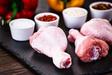 Raw chicken drumsticks on wooden background
