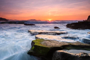 Fotobehang amazing sunset landscape at rocky beach © jon_chica