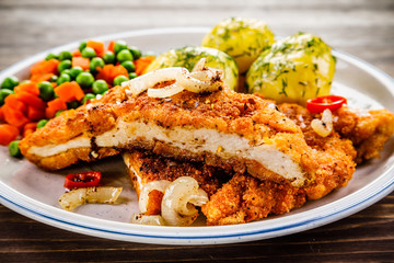Fried pork chop with potatoes and vegetable salad