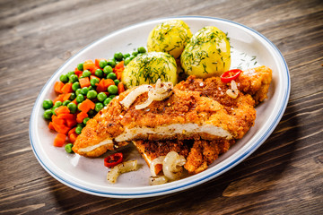 Fried pork chop with potatoes and vegetable salad