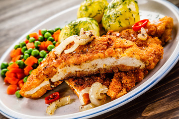 Fried pork chop with potatoes and vegetable salad