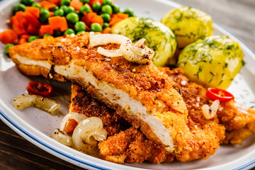 Fried pork chop with potatoes and vegetable salad