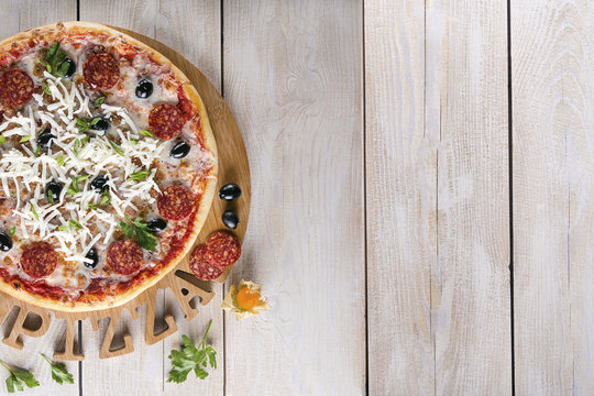 Pepperoni pizza on rustic background. Top view with copy space.