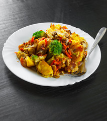 Mixed vegetables and mushrooms in a plate on dark wooden table