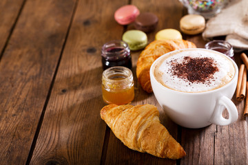 Cup of cappuccino coffee with croissants