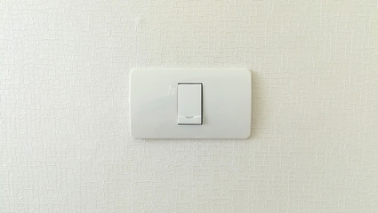single white lighting switch on wall