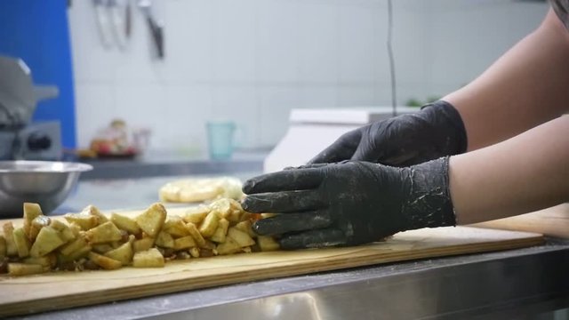 Cook woman prepares fresh fruits for apple strudel on dough