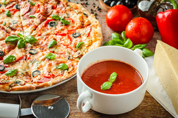 pizza and ingredients on a wooden background.