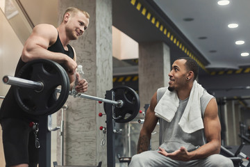 Man and personal trainer exercising with dumbbell