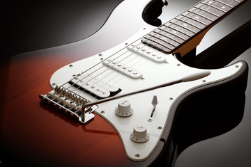 Close up on the body of elegant electric guitar with sunburst finish, black glossy background