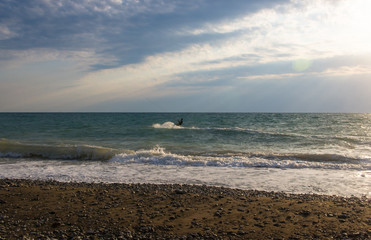 kitesurfer rides a kite-surf on waves of the sea