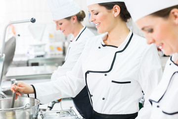 Female chefs at work in industrial kitchen of canteen 