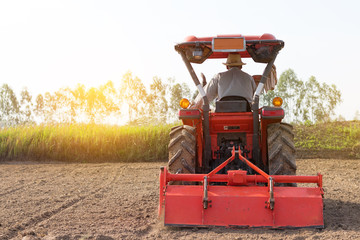 Agriculture. Tractor plowing field. Wheels covered in mud, field in the backround.