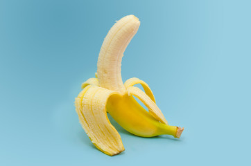 Fresh peeled banana on blue background