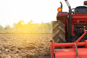 Agriculture. Tractor plowing field. Wheels covered in mud, field in the backround.