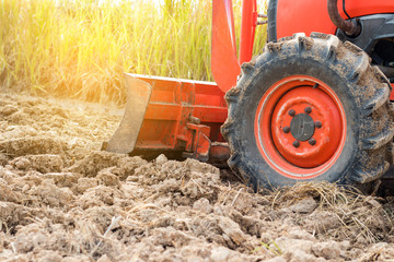 Tractor tire on field. Agriculture Tractor plowing field.