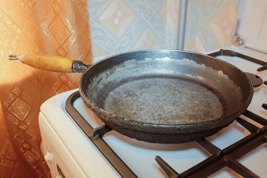 Старая чугунная сковородка на газовой плите в кухне