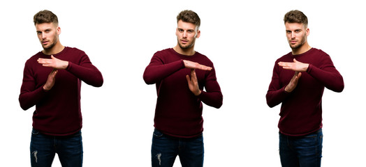 Handsome blond man serious making a time out gesture with hands isolated over white background