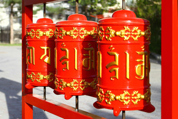 Photo of the Red prayer drums in a Buddhist temple at day time.