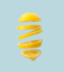Flying lemon. Sliced lemon isolated on blue background. Levity fruit